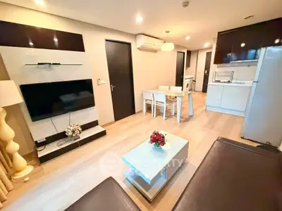 Modern living room with open kitchen, sleek furniture, and ambient lighting in a stylish apartment.
