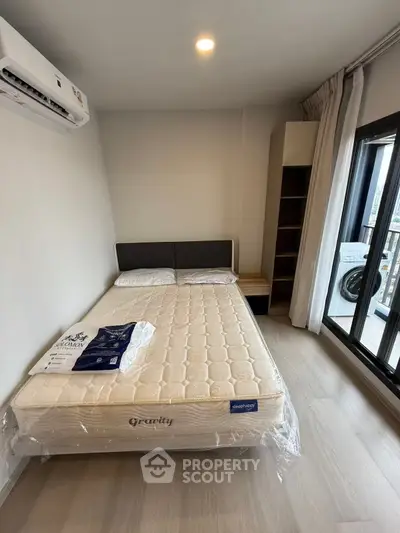 Modern bedroom with balcony access and air conditioning in a stylish apartment.