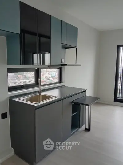 Modern minimalist kitchen with sleek cabinetry and city view