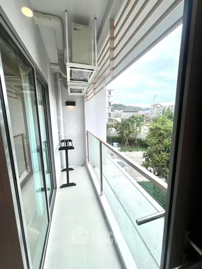 Modern apartment balcony with glass railing and scenic view