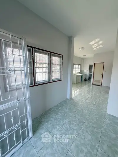 Spacious interior with tiled flooring and large windows, perfect for natural light.