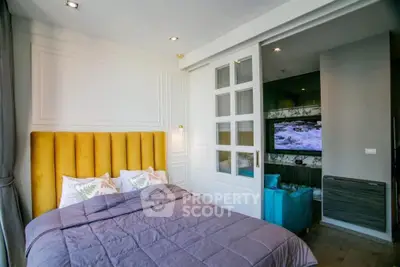 Modern bedroom with stylish decor and sliding doors leading to a cozy living area.