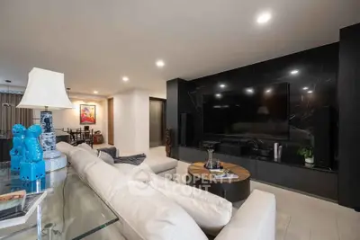 Luxurious modern living room with sleek black entertainment wall and plush white seating.
