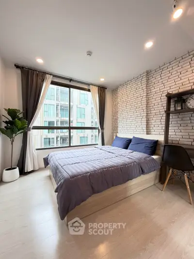Modern bedroom with large window and stylish brick accent wall
