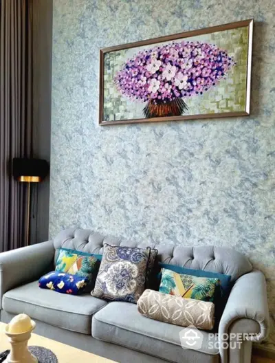 Elegant living room with stylish sofa and floral artwork on textured wall.