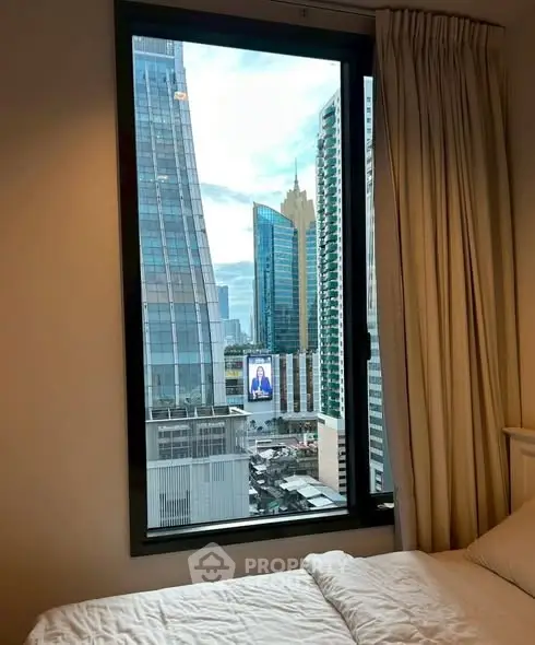 Stunning cityscape view from a modern bedroom window in a high-rise apartment.