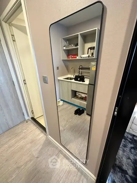 Modern compact kitchen with sleek cabinetry and stylish mirror