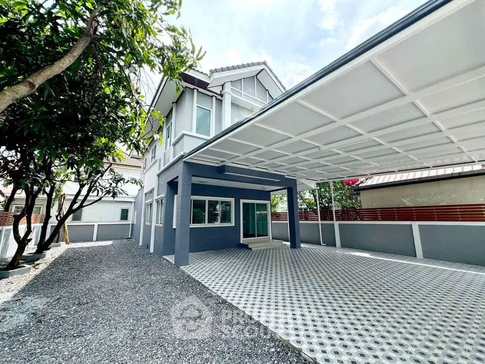 Modern two-story house with spacious carport and gravel driveway