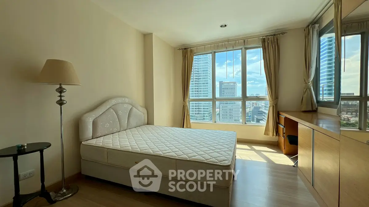Bright bedroom with city view, large windows, and modern furnishings.