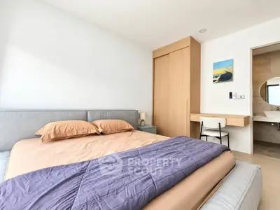 Modern bedroom with cozy bed and built-in wardrobe in a stylish apartment.