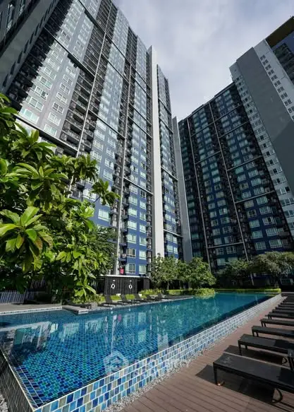 Modern high-rise building with a luxurious pool and lush greenery, perfect for urban living.