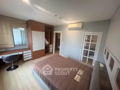 Spacious bedroom with modern design, featuring built-in wardrobe and stylish furniture.