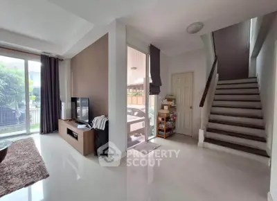 Spacious modern living room with natural light and staircase