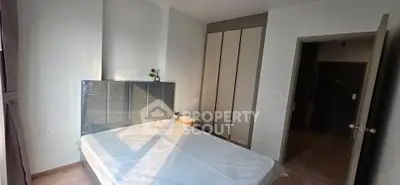 Modern bedroom with large window and built-in wardrobe, perfect for cozy living.