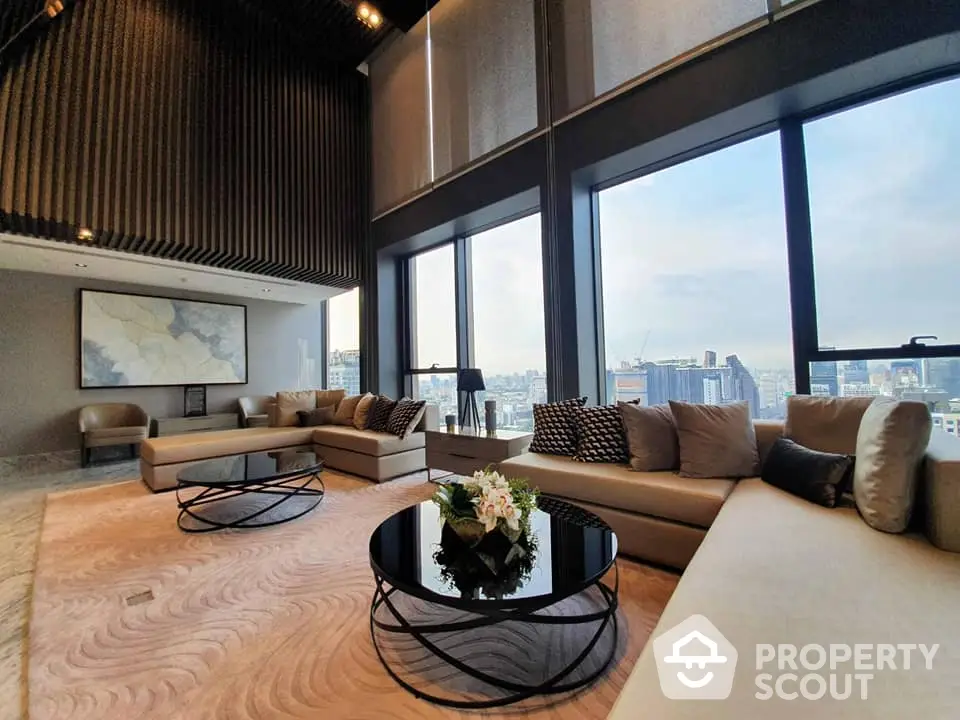 Luxurious high-rise living room with floor-to-ceiling windows offering panoramic city views, complemented by stylish furniture and elegant interior design.