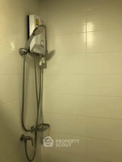 Modern bathroom with sleek shower unit and tiled walls, perfect for a refreshing experience.