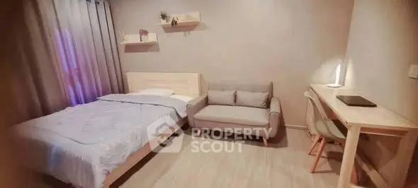 Cozy bedroom with modern decor, featuring a bed, sofa, and study desk in a well-lit space.