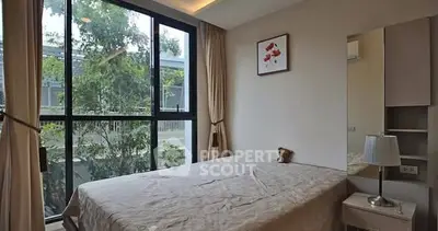 Cozy bedroom with large window and elegant decor in modern apartment