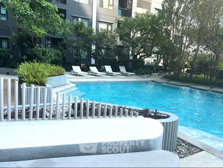 Luxurious apartment complex with a stunning outdoor pool and lush greenery.