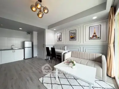 Modern living room with open kitchen, stylish decor, and ample natural light in a contemporary apartment.