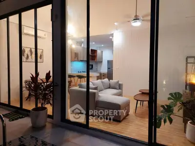 Modern living room with open kitchen, featuring cozy sofa and stylish decor, perfect for contemporary living.
