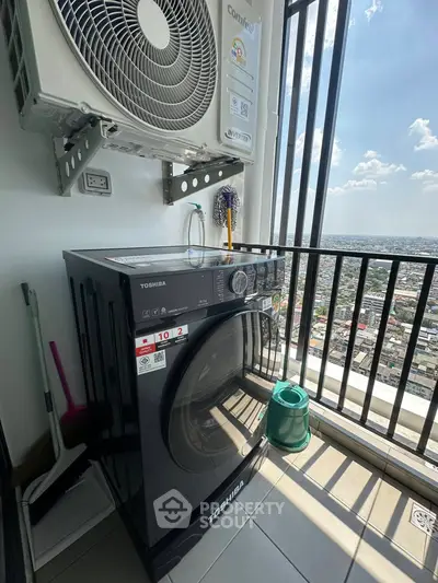 High-rise balcony with washing machine and city view, perfect for urban living convenience.