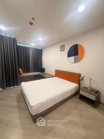 Modern bedroom with stylish decor and large window, featuring a comfortable bed and contemporary furnishings.