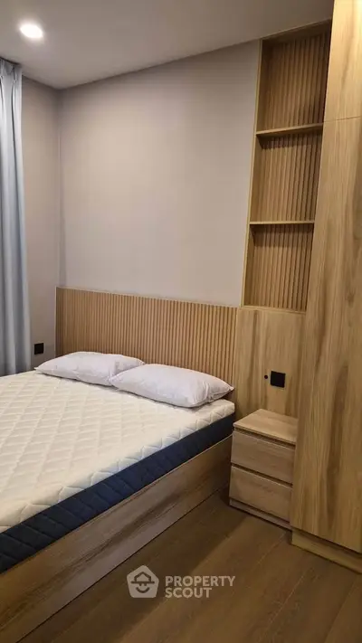 Modern bedroom with wooden accents and built-in storage, featuring a comfortable bed and elegant design.
