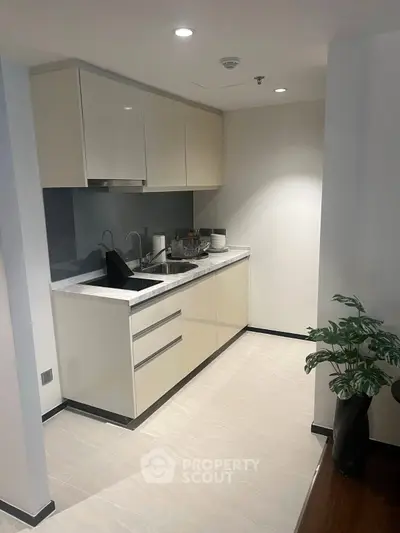 Modern kitchen with sleek cabinetry and marble countertops in a contemporary apartment.