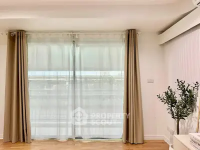 Bright living room with large window and elegant curtains