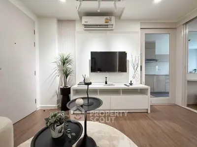 Modern living room with sleek design, featuring a wall-mounted TV, stylish furniture, and elegant decor.
