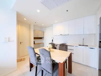 Modern kitchen with sleek white cabinets and elegant dining area