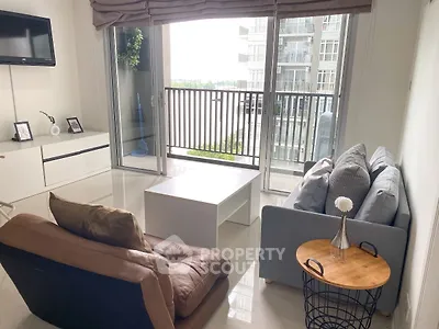 Modern living room with balcony view, stylish furniture, and natural light.