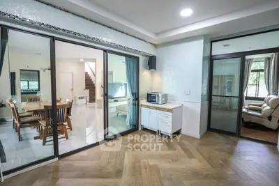 Spacious open-plan living area with modern kitchen and dining space, featuring elegant wood flooring and ample natural light.