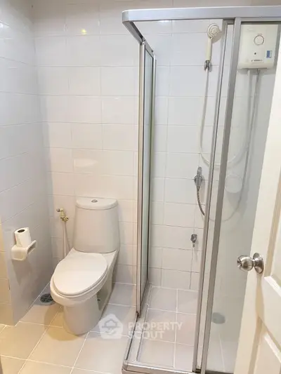 Modern bathroom with sleek shower and toilet in a minimalist design.