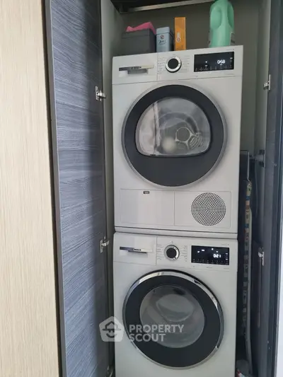 Modern laundry area with stacked washer and dryer in sleek cabinet