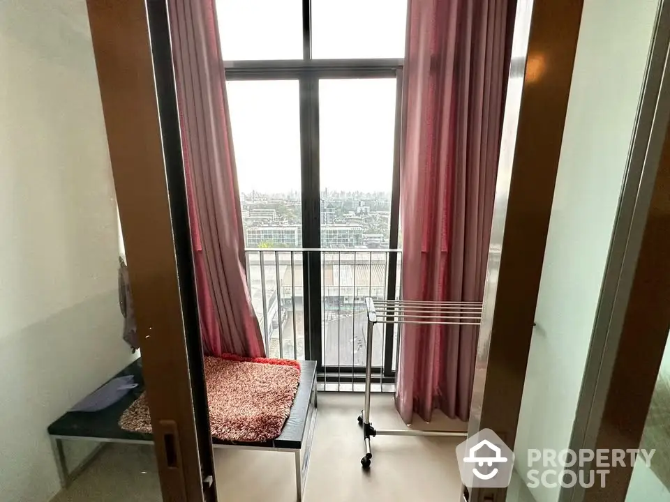 Cozy small room with balcony view and pink curtains in modern apartment