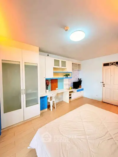 Bright and modern bedroom with built-in desk and storage, perfect for a cozy living space.