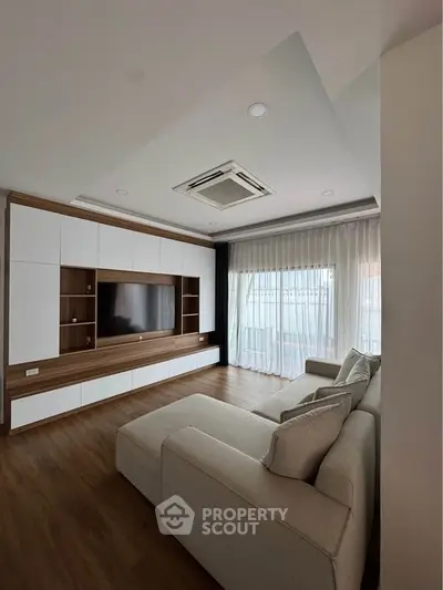 Spacious modern living room with elegant built-in entertainment unit and cozy sectional sofa.