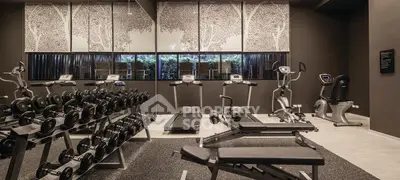 Modern gym with state-of-the-art equipment and serene decor in luxury residential building.