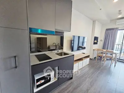 Modern open-layout kitchen and living area with sleek appliances and balcony view.