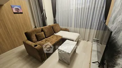 Cozy living room with plush brown sofa, modern decor, and large TV for ultimate relaxation.