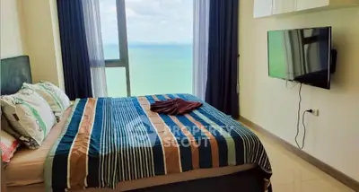 Stunning bedroom with ocean view and modern amenities in a high-rise apartment.