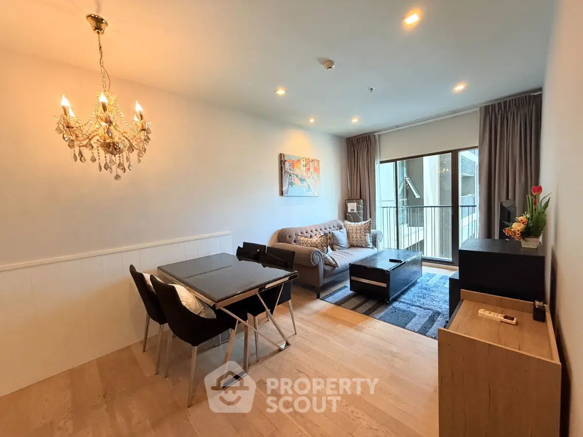 Elegant living room with chandelier and balcony view in modern apartment