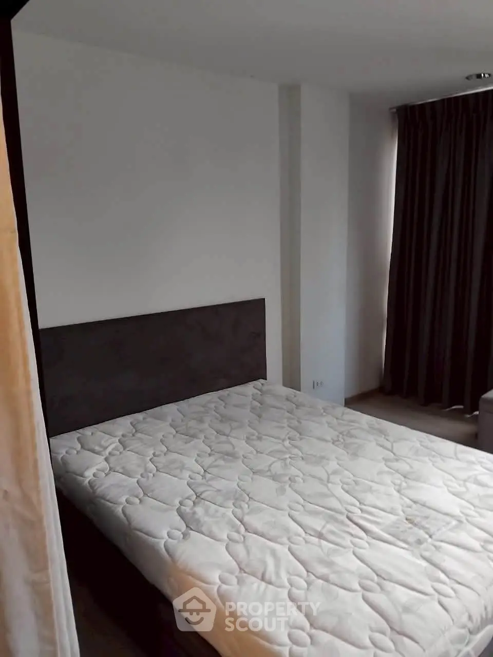 Cozy bedroom with natural light and modern furnishings in a stylish apartment.