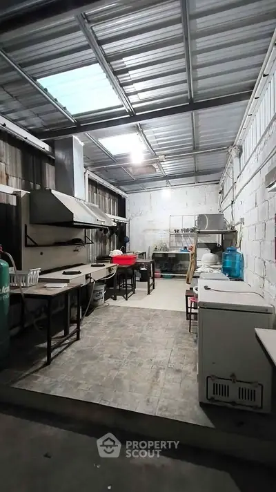 Spacious industrial-style kitchen with metal roof and ample workspace, ideal for culinary enthusiasts.