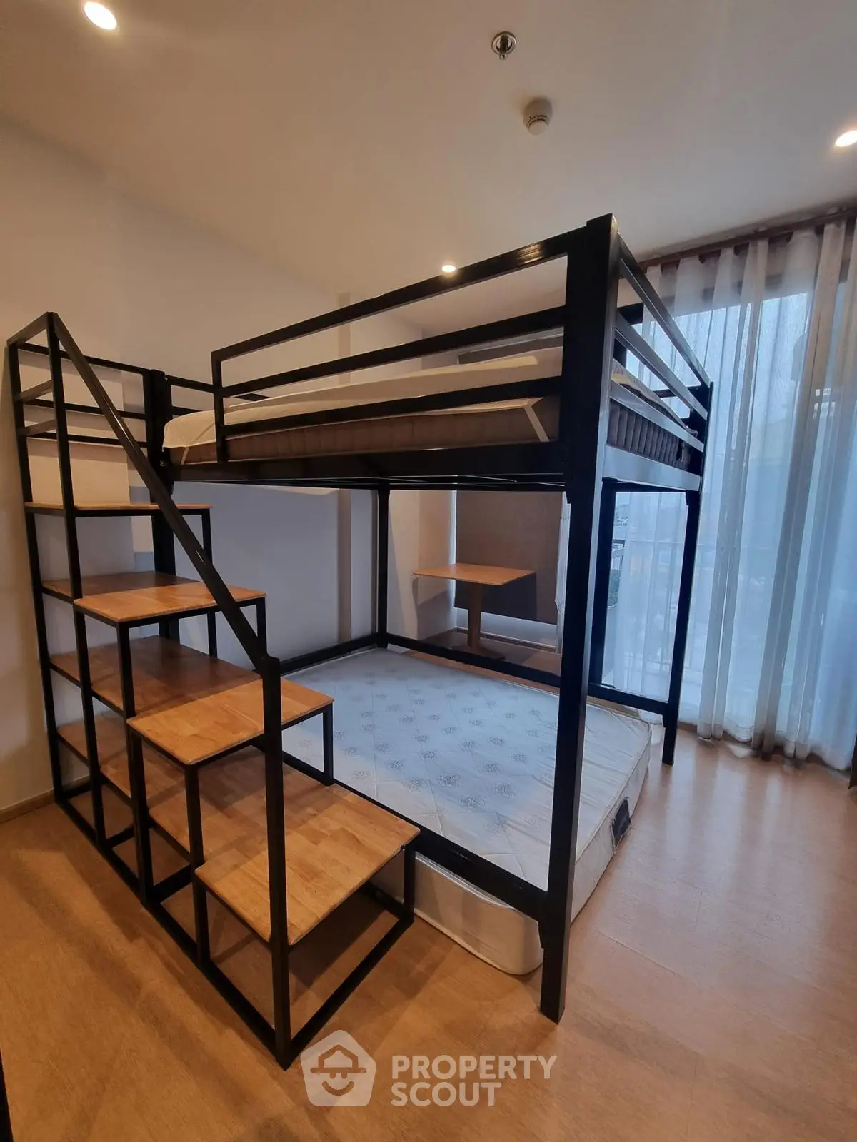 Modern loft-style bedroom with bunk bed and wooden flooring