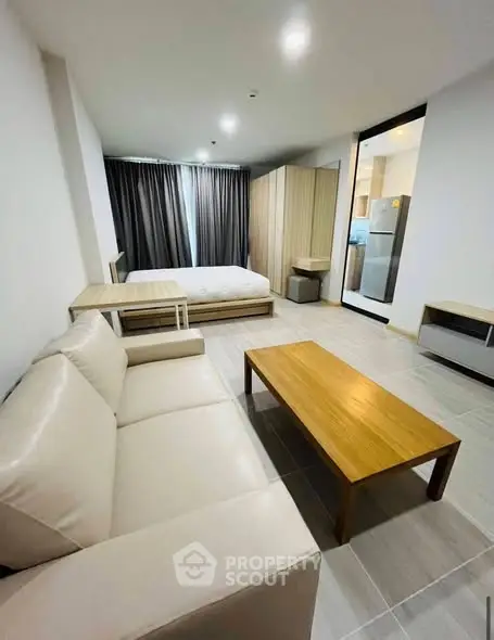Modern studio apartment with open layout, featuring cozy living area and stylish furnishings.