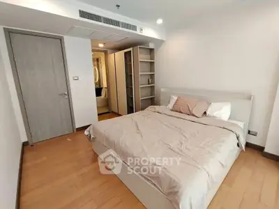 Spacious bedroom with modern design and ample storage in a stylish apartment.