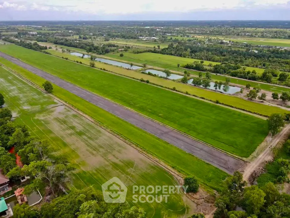 Expansive aerial view of lush green farmland with clear skies, ideal for agricultural investment.